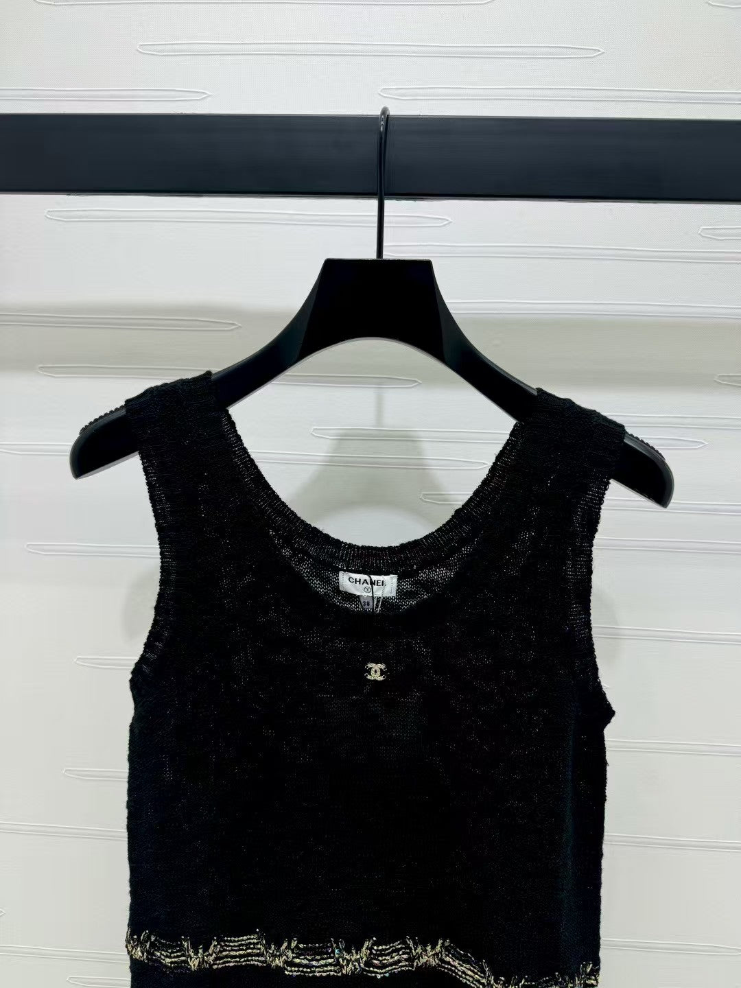 Knitted vest with gold embroidered hem