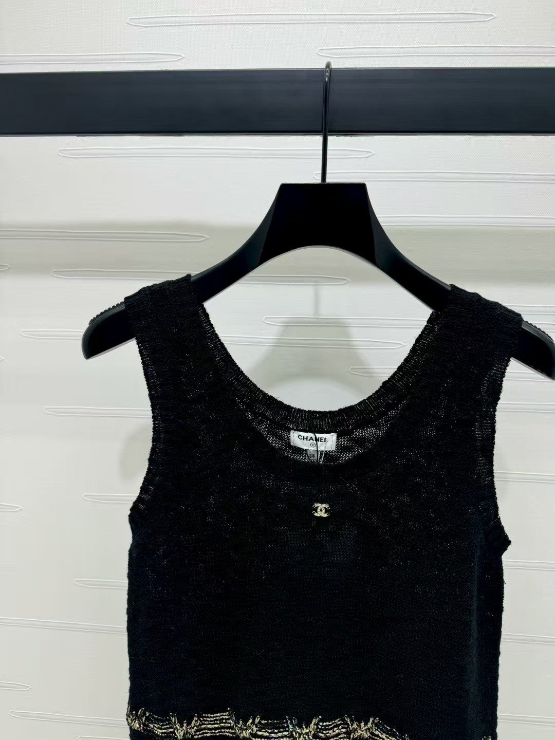 Knitted vest with gold embroidered hem