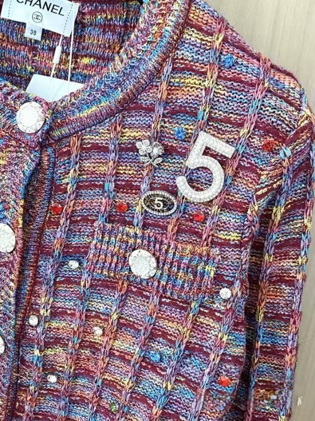 Patterned buttons and logo embellishments on cardigan