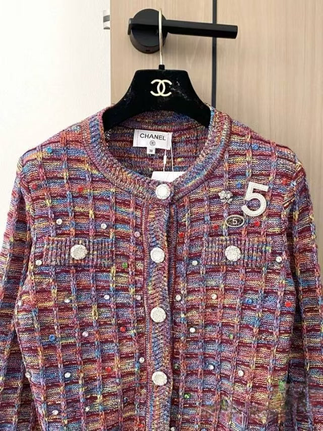 Patterned buttons and logo embellishments on cardigan